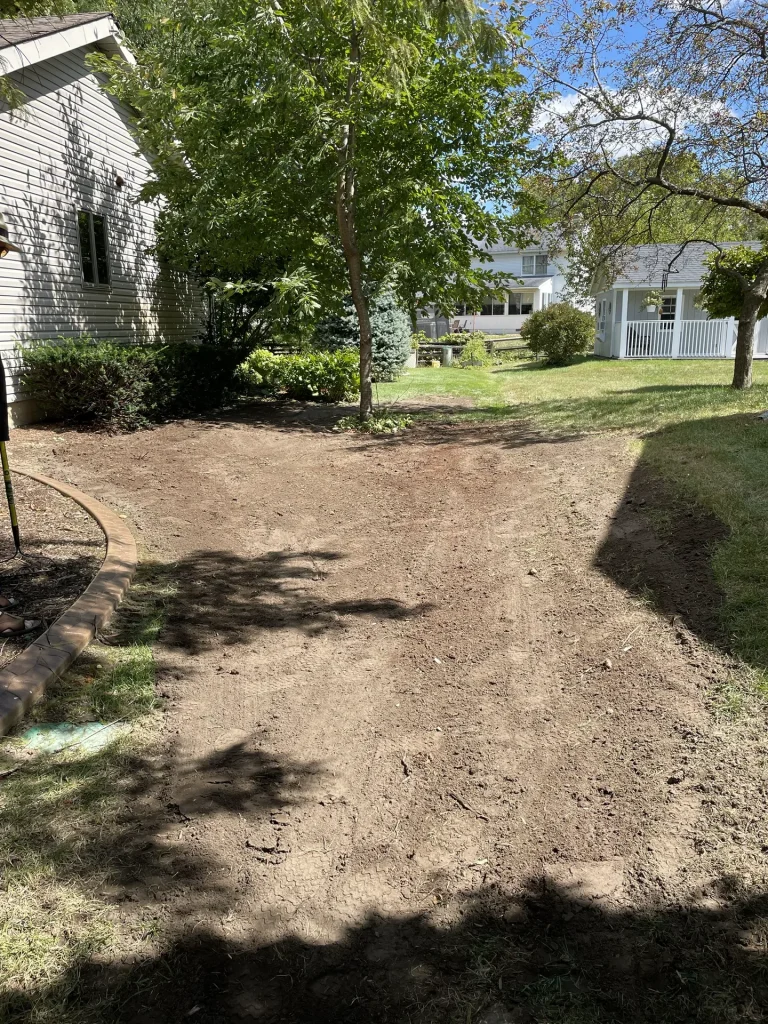 Better Way Land Management prepared bare soil area in residential backyard ready for seeding near mature trees in Ohio