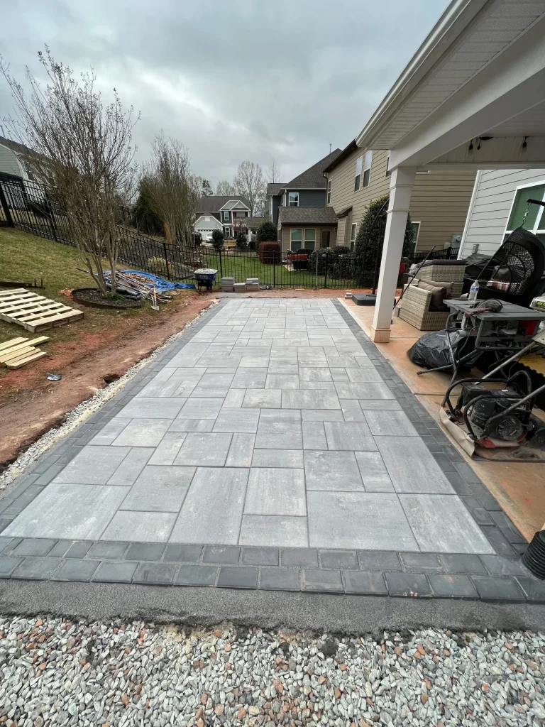Better Way Land Management LLC completed gray rectangular paver patio with dark border edging in residential backyard Ohio