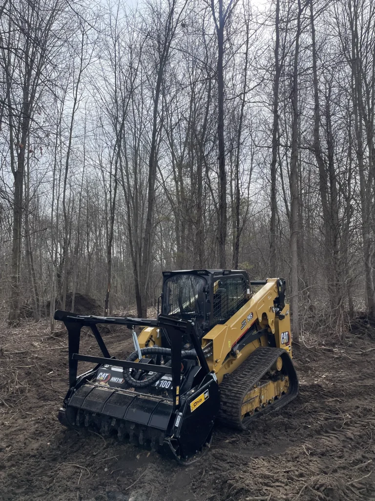 Better Way Land Management LLC CAT 265 compact track loader with HM316 forestry mulcher clearing wooded terrain during land management project